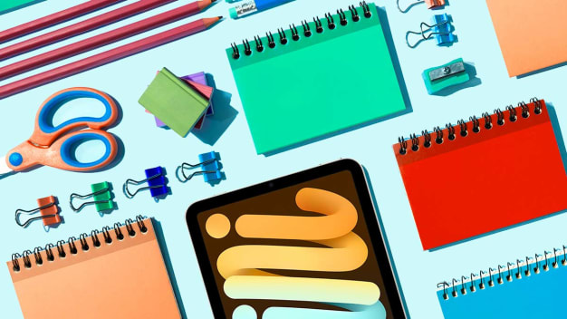 School supplies and iPad on blue background