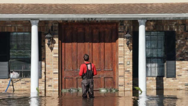 A man stops in front of his house as a creek overflows from flooding following Hurricane Ian on September 30, 2022 in Kissimmee, Florida.