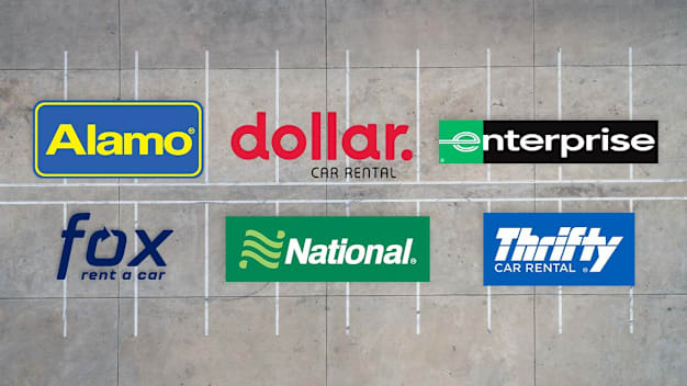 Alamo, Dollar, Enterprise, Fox, National, and Thrifty logos on a parking lot background.