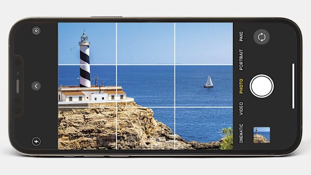 Phone with photo of lighthouse overlayed with three-by-three composition grid on the camera display