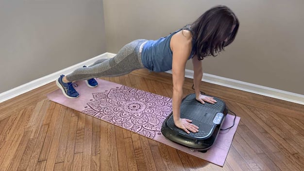 Consumer Reports editor doing a plank on the Lifepro Waver Vibration Plate Exercise Machine in her home.