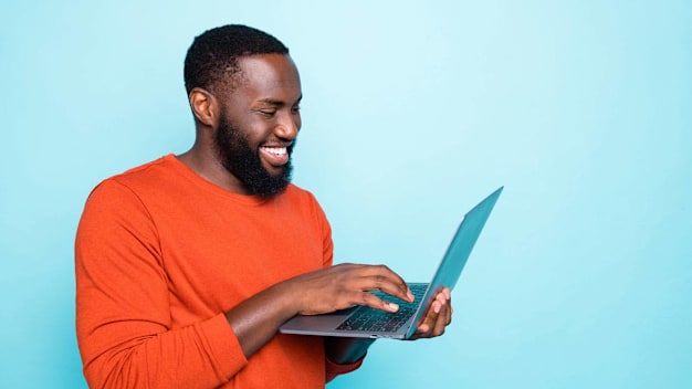 A man typing on a laptop while holding it.