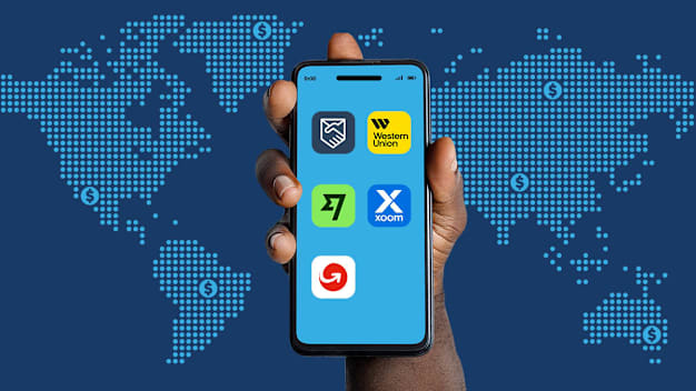 Hand with phone displaying the icons of tested remittance apps.