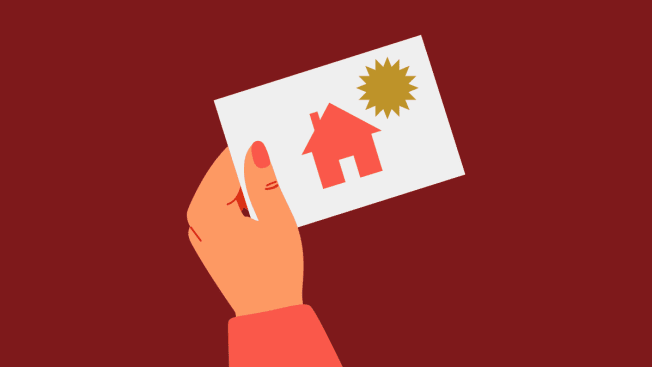 Hand holding a card with a house on it.