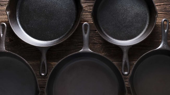 overhead shot of 5 cast iron pans on wood surface
