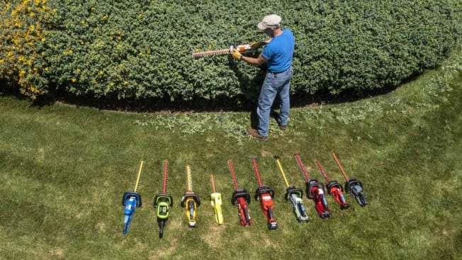 overhead view of Consumer Reports tester testing a hedge trimmer with several hedge trimmers lined up on ground near them