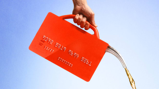 A person pouring gasoline out of a credit card shaped like a gas can.