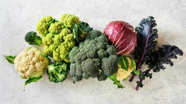 overhead view of cauliflower, broccoli, cabbage, and kale