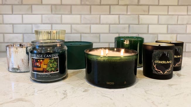 several pine-scented candles on marble countertop