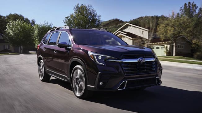 2023 Subaru Ascent in purple on road in suburban neighborhood with trees and houses in background