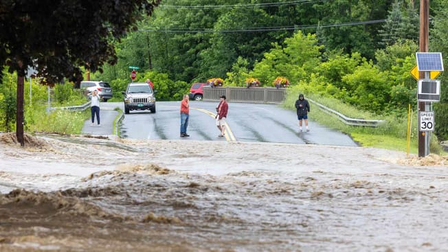 Onlookers check out a flooded road on July 10, 2023 in Chester, Vermont.
