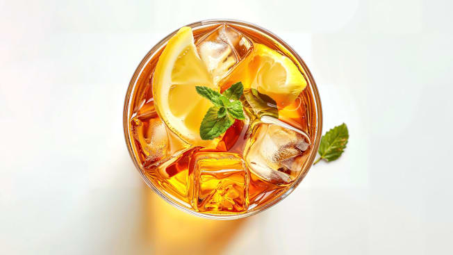 Iced tea in a glass with lemon and mint.