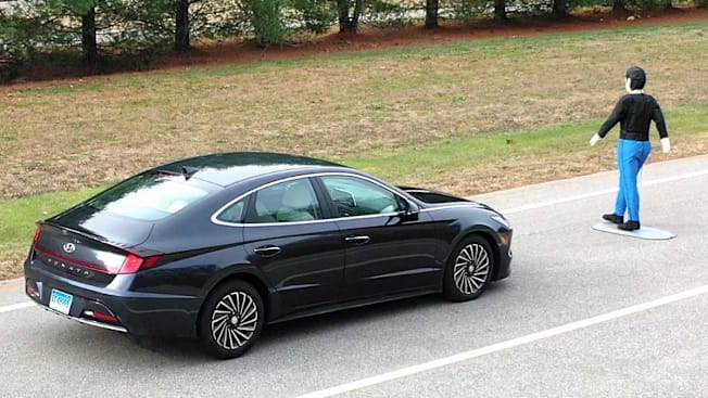 black Hyundai Sonata on road with inflatable test dummy in front of the car in order to test automatic emergency braking system