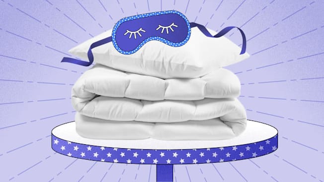 A white comforter and pillow with a blue sleep mask on top, set on a starry platform against a purple background.