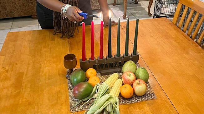 Camille Briggs lighting Kwanzaa candles