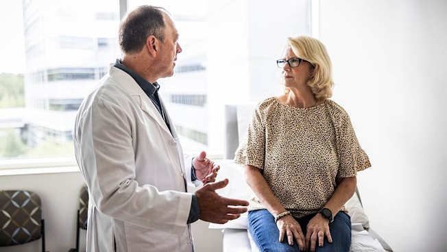 Doctor consulting with patient in exam room.