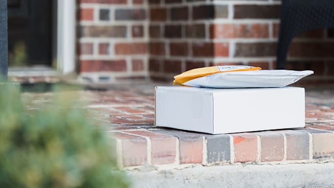 Packages sitting on the stoop in front of a home.