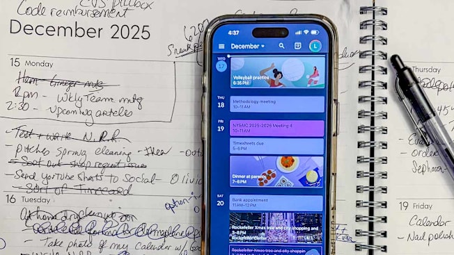 phone showing calendar events resting on paper calendar showing events