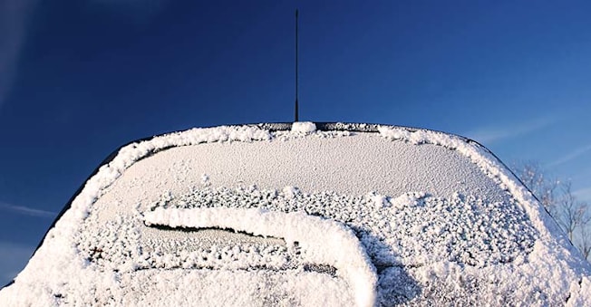 Windshield of a car covered in snow.