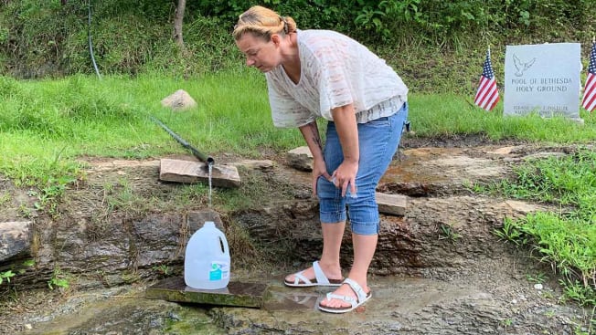 BarbiAnn Maynard, a citizen water advocate, collects spring water at the Pool of Bethesda in Mingo County, W.Va. Maynard uses the water for drinking and cooking because she doesn’t trust Martin County’s tap water.