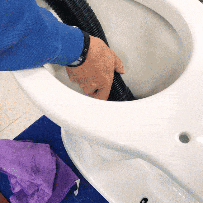 gif of technician vacuuming water from tested toilet