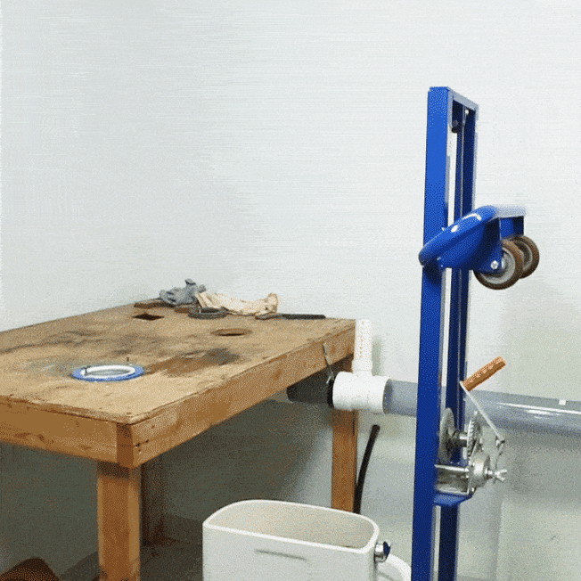 A toilet being lifted by crank elevator in a Consumer Reports lab