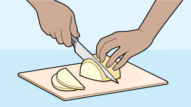 Cutting an onion on a cutting board properly holding a chef's knife