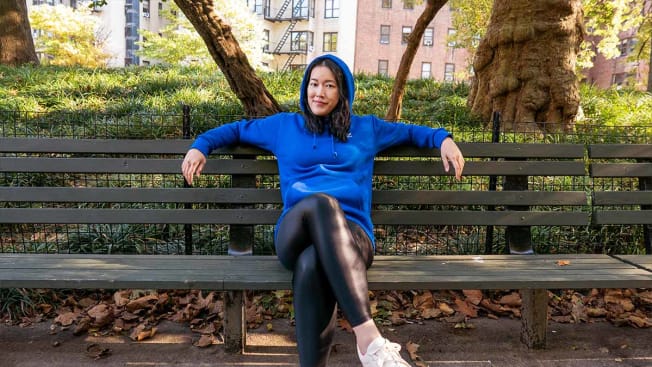 Perry Santanachote sitting on a bench wearing a hoodie made by Adidas.