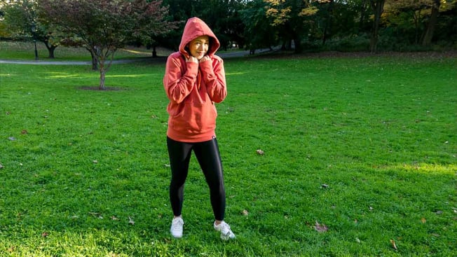 Perry Santanachote standing in her neighborhood park wearing in a hoodie by American Giant.
