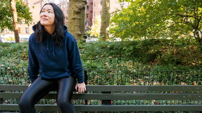 Perry Santanachote sitting on a bench wearing a hoodie made by The Gap.
