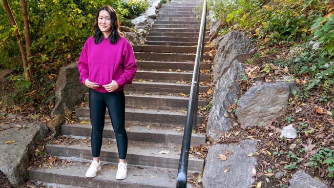 Perry Santanachote standing in her neighborhood park wearing in a hoodie designed by Yeezy.
