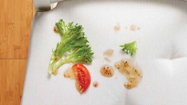 lettuce and tomato with salad dressing on white chair