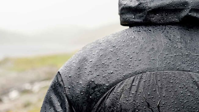 man wearing waterproof puffer jacket in the rain outside