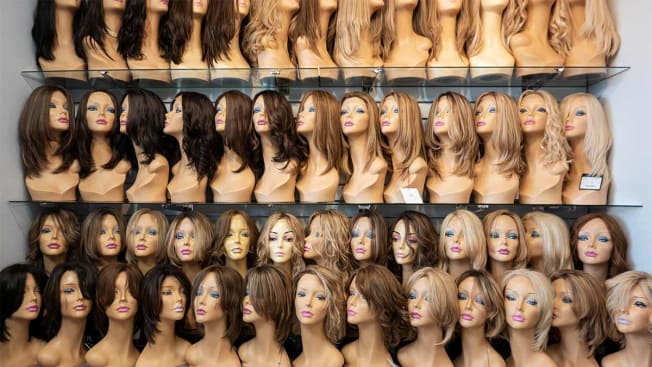 wall of mannequin heads wearing wigs