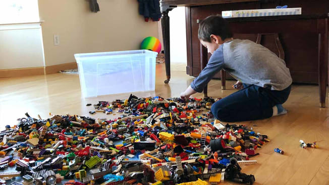 Oliver sorting through a large pile of legos on the floor.