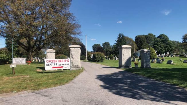 sign in front of cemetery directing to Chicken Bar-B-Q inside the cemetery