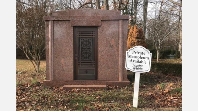 mausoleum with sign in front of it saying "Private Mausoleum Available, Inquire Within"