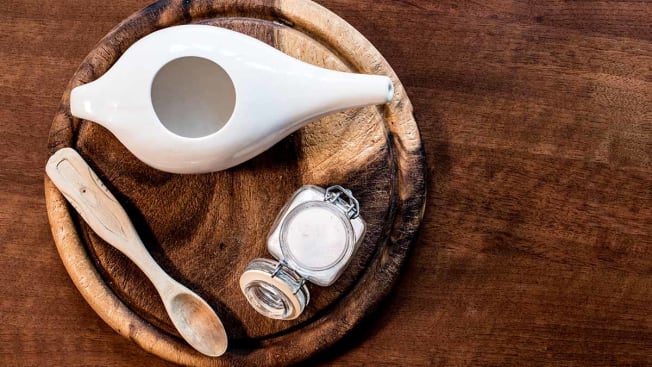 neti pot with salt on a wooden background
