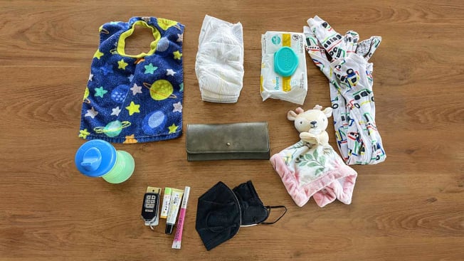 baby bottle, diapers, baby clothings, and toiletries on a wooden background