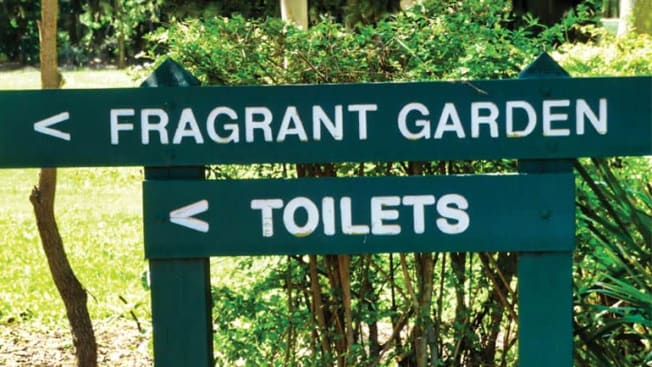 sign pointing in the same direction for both 'Fragrant Garden' and 'Toilets'