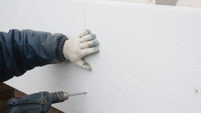 a person installing foam board insulation