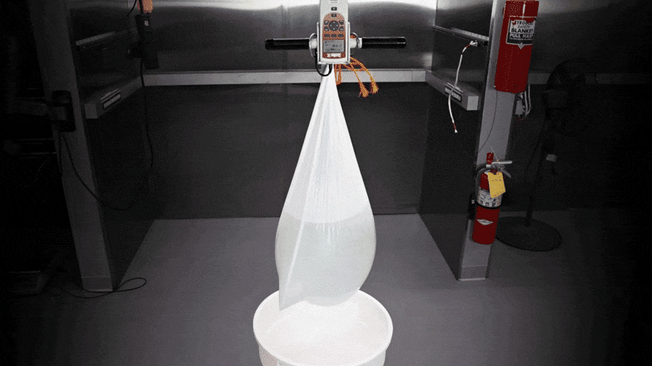 A trash bag is tested by hanging it over a bucket, filling it with water, and seeing how much force it takes to break it.