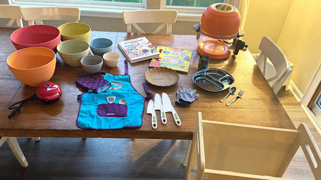 a dining table with cooking supplies made for children learning to cook