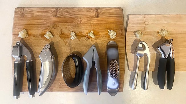 Garlic presses on cutting boards with minced garlic