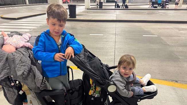 two children in a stroller at an airport parking lot