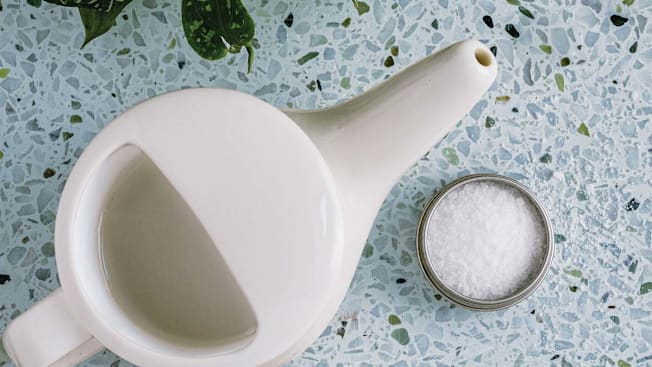 overhead view of neti pot and saline salts on countertop