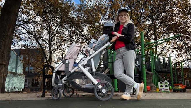 Angela Lashbrook standing in a playground next to the Bugaboo Vista stroller.