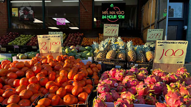 fruit stand with mandarins, dragonfruits, pineapples, and kabochas for sale