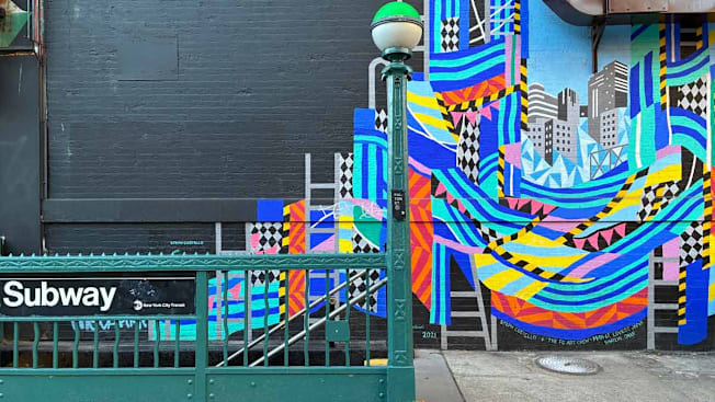 NYC subway entrance at Fulton Street, showing abstract colorful mural on wall