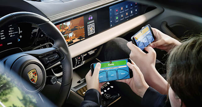 2026 Porsche Macan Electric showing passengers playing games
